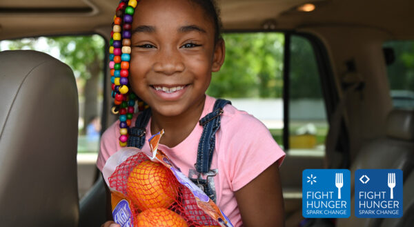 Photo of girl holding bag of oranges with Walmart and Sam's Club Fight Hunger. Spark Change. logos