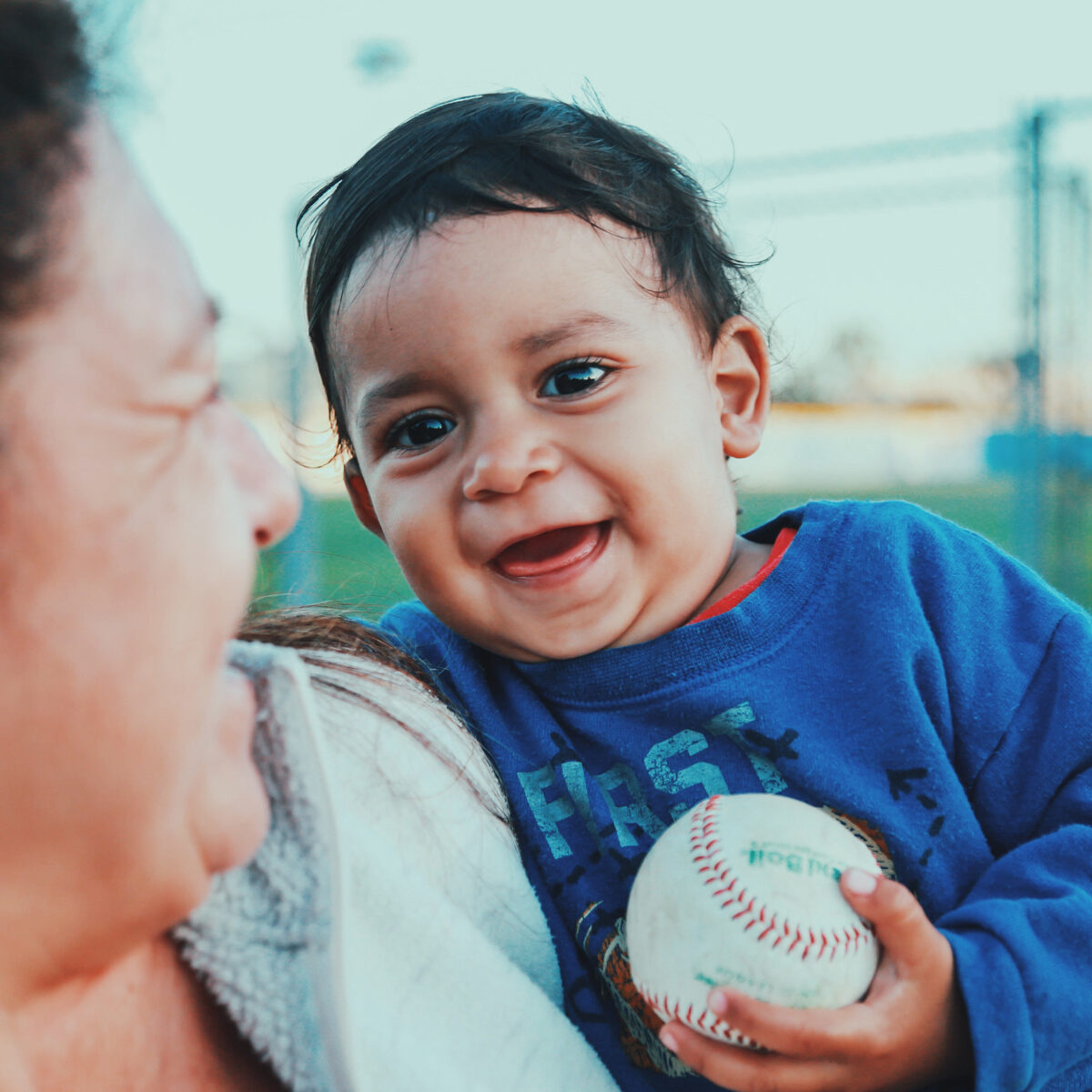 Photo of child holding a baseball and smiling