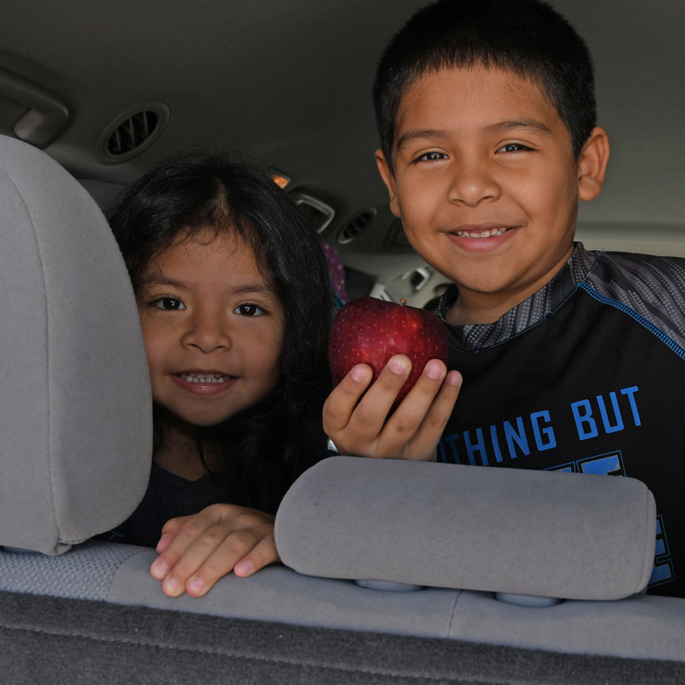 Kids in Car Holding Apples Smiling